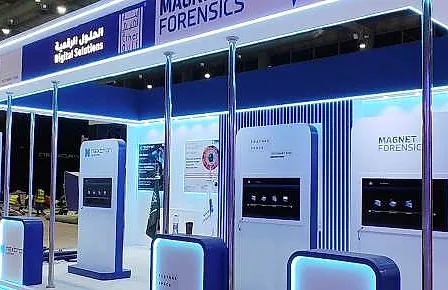جناح Digital Solutions: إطار أبيض مضاء بالأزرق، مع أكشاك الشركاء وشاشات ومكاتب مضاءة
