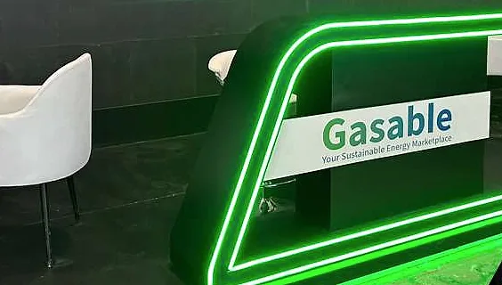 مكتب Gasable محدّد بإضاءة نيون خضراء ساطعة، مع شعار Gasable ومقعد استراحة أبيض